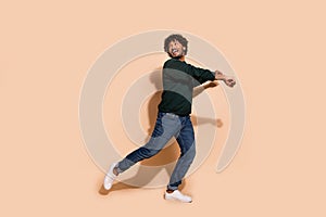 Full body portrait of nice young man enjoy dancing wear sweater isolated on beige color background