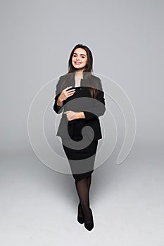 Full body portrait of professional business woman with blanck standing on gray background