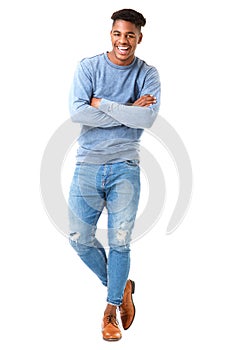 Full body smiling young black man standing with arms crossed against isolated white background photo