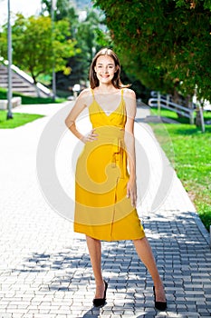 Full body portrait of a young beautiful woman in yellow dress