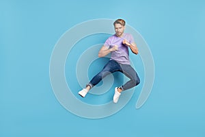 Full body portrait of young person look interested empty space fists ready to fight isolated on blue color background