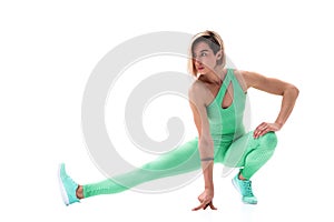 Full body portrait of young sporty woman stretching before exercise isolated on white background