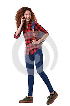 Full body young woman walking on isolated white background with cell phone and bag