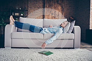 Full body profile photo of domestic handsome guy stay home quarantine time fall asleep reader book on floor lying