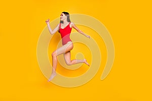 Full body profile photo of funny lady jumping high seaside sportive competitions champion speed jogging wear red swim