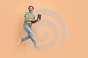 Full body profile portrait of energetic man hold use wireless netbook isolated on beige color background