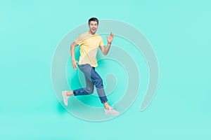 Full body profile portrait of excited energetic man running hurry speed  on teal color background