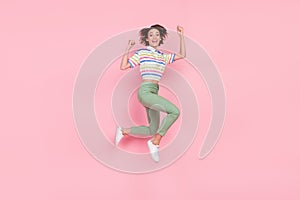 Full body profile side photo of young girl happy positive smile rejoice success jump isolated over pink color background