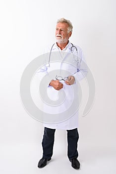 Full body shot of handsome senior bearded man doctor standing an