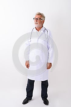 Full body shot of handsome senior bearded man doctor standing an