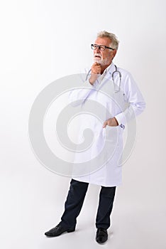 Full body shot of handsome senior bearded man doctor standing an