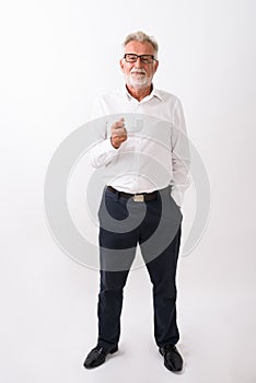 Full body shot of handsome senior bearded man standing and holdi