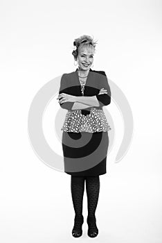 Full body shot of happy senior Asian businesswoman smiling while standing with arms crossed against white background