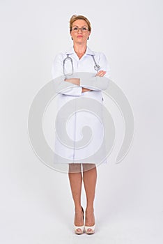 Full body shot of mature woman doctor with arms crossed