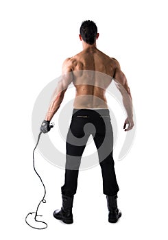 Full body shot of muscular man with whip and leather glove, seen from the back