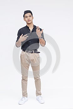 Full-body shot of a young Asian man gesturing as he discusses his qualifications, isolated on a white backdrop