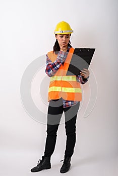 Full body shot of young Asian woman construction worker standing