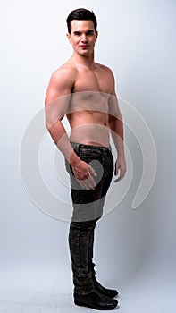 Full body shot of young handsome muscular man shirtless