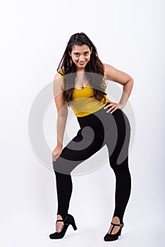 Full body shot of young happy Indian woman smiling while posing