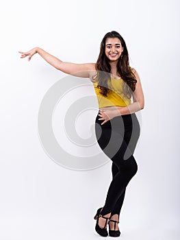 Full body shot of young happy Indian woman smiling while posing