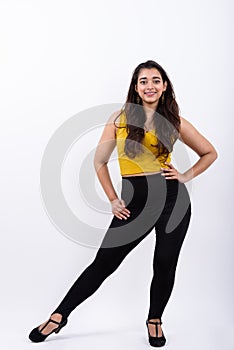 Full body shot of young happy Indian woman smiling while posing