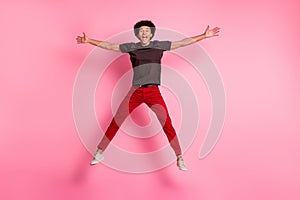 Full body size photo of overjoyed funky guy jumping trampoline star symbol celebrate best day his life isolated on pink