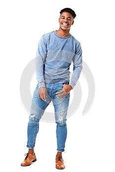 Full body smiling young black man standing against isolated white background