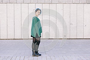 full body of a teen androgynous woman with blue dyed hair isolated on the street