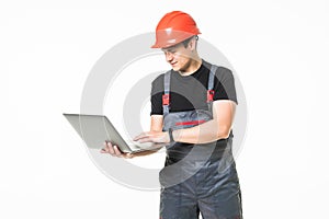 Full body view of a construction contractor working on his laptop on white background