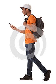 Full body young african american man walking on isolated white background with cellphone and bag