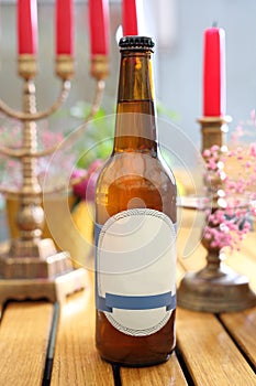 Full bottle of craft beer, mock-up with a blank label for package design, on a wooden table, selective focus.