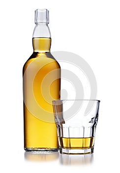 A full bottle of golden whisky, with no label or branding, and a glass of whisky, isolated on white