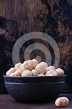 Full bowl of hazelnuts on table with copy space