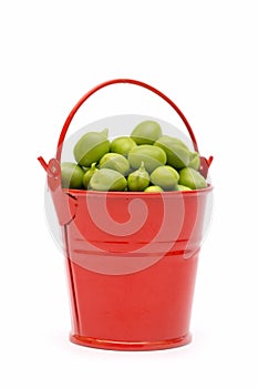 Full bucket of green peas on a white background