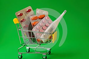 A full cart from the pharmacy with medicines and pills on a green background