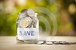 Full coins in a jar. Saving money concept and save money to support everything in life with sun light bokeh background