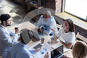 Full concentration at work. Group of young business people working and communicating while sitting at the office desk