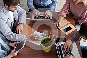 Full concentration at work. Group of young business people working and communicating while sitting at the office desk