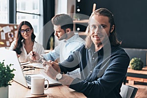 Full concentration at work. Young modern colleagues in smart casual wear working while spending time in the office