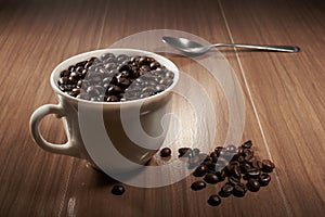 full cup of black coffee and spoon