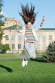 Full of energy. childhood happiness. small girl with curly hair jump outdoor. spring holiday celebration. child fly in