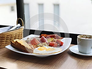 Full English breakfast with fried eggs, sausages, bacon, beans and toasts