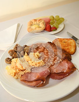 Full English breakfast with fruit and pastries