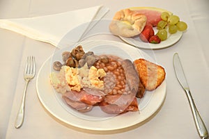 Full English breakfast with fruit and pastries