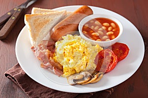 Full english breakfast with scrambled eggs, bacon, sausage, bean