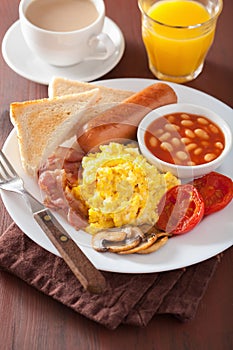 Full english breakfast with scrambled eggs, bacon, sausage, bean