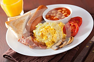 Full english breakfast with scrambled eggs, bacon, sausage, bean