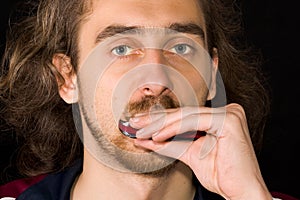 Full face portrait of man playing harmonica