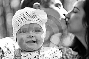 Full-fledged happy family. Girl and kissing parents