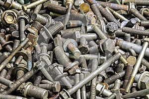 full frame background of used automobile bolts heap, old and dirty